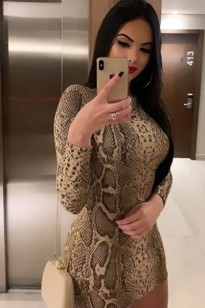 brunette escort Amsterdam Joya tight snake print dress mirror selfie curves accentuated bold look