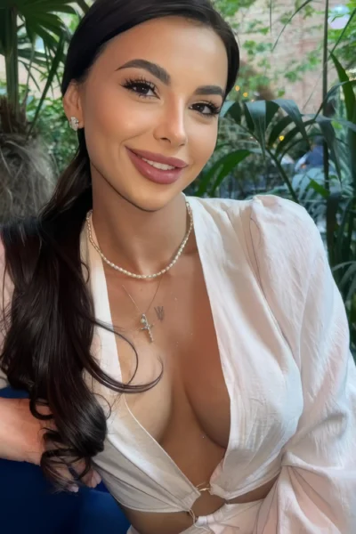 Daniela smiling outdoors in a white dress in Amsterdam